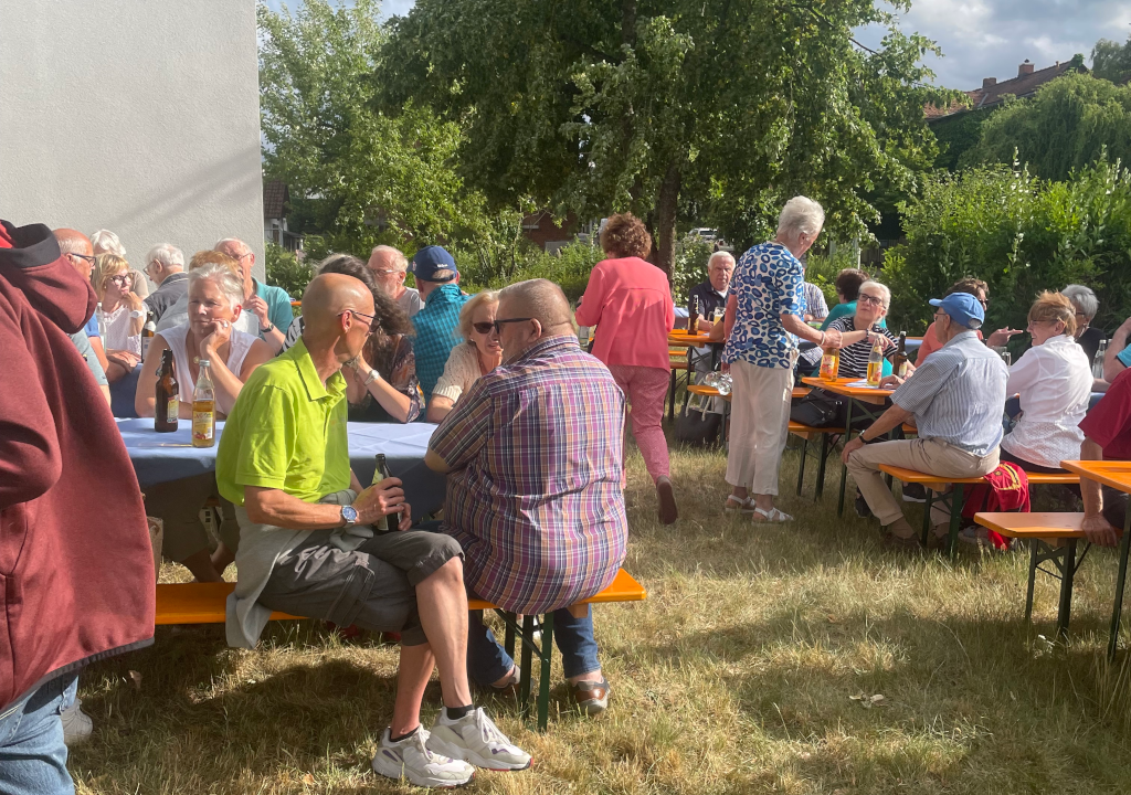 Feiernde Tafelhelfer auf Bierbänken